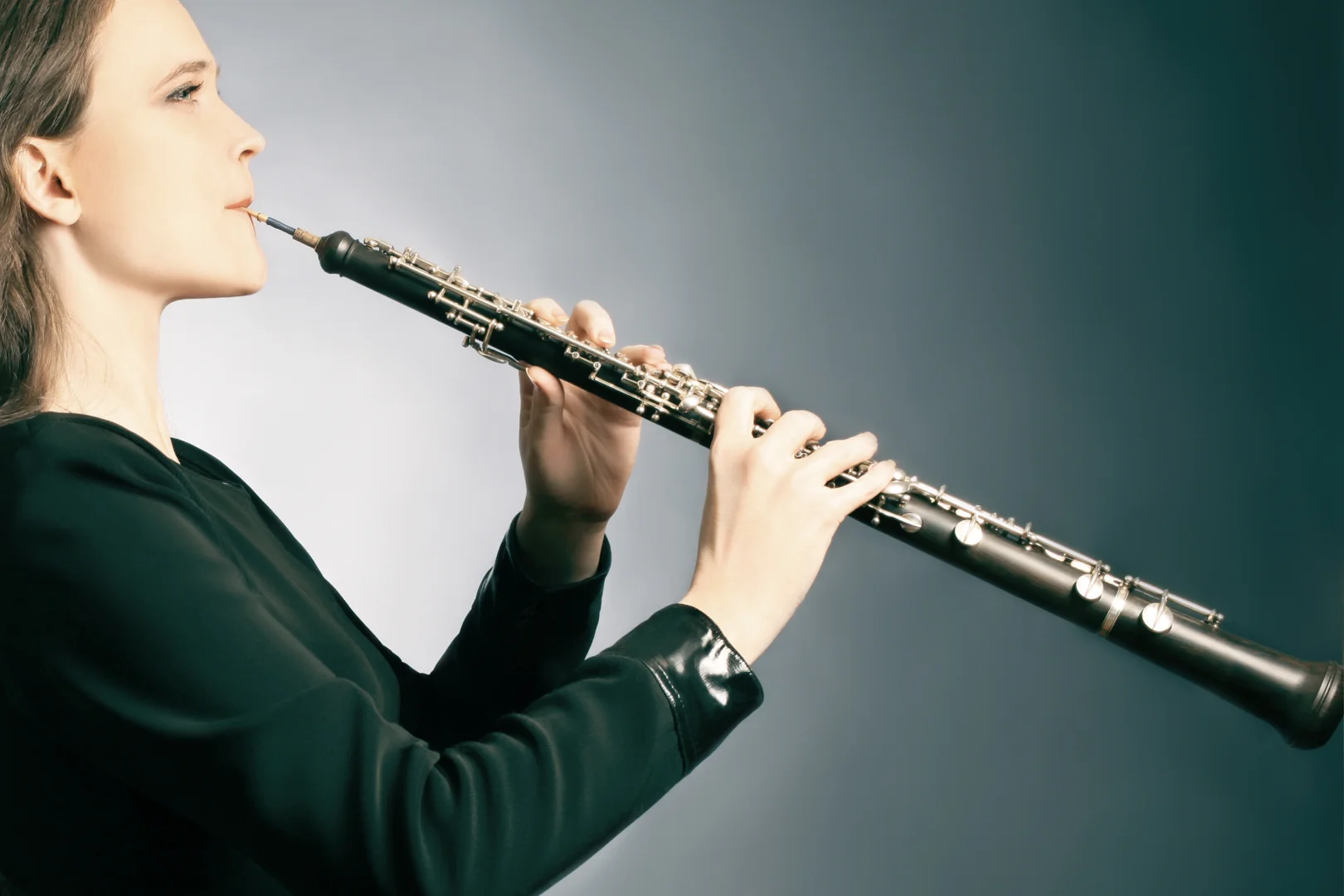 Woman graciously playing oboe windwood instrument